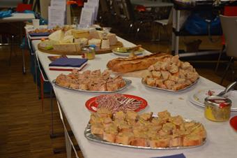 Ein Tisch ist gedeckt mit vielen Tellern und Tabletts. Darauf befinden sich verschiedene Französische Köstlichkeiten wie z.B. Käse.
